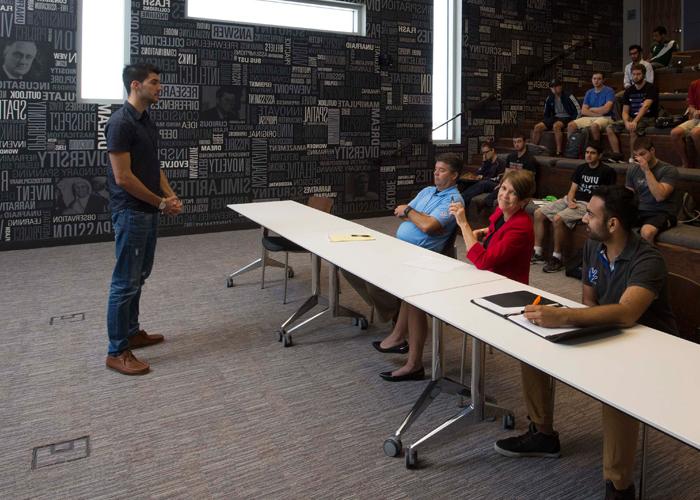 People listening to a person giving a pitch